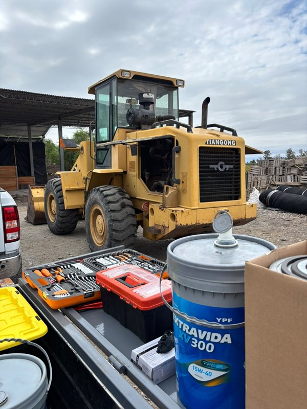 Cargadora frontal amarilla con herramientas y lubricante YPF Extravida preparados para el service