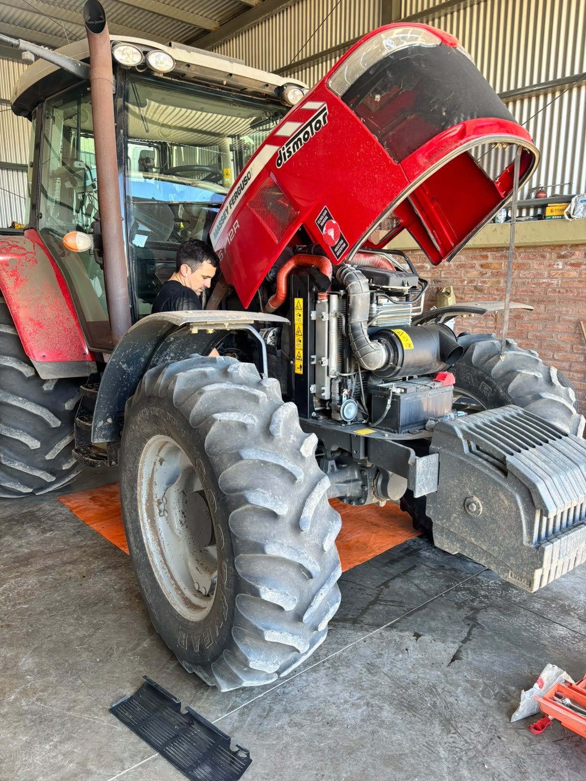 Tractor Massey Ferguson rojo con el capó abierto durante un service de maquinaria agrícola