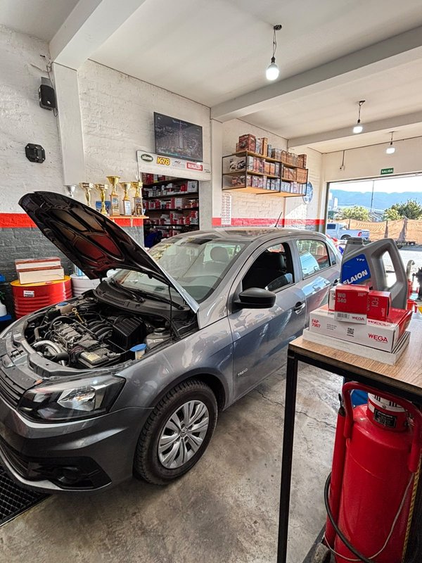 Auto Volkswagen gris con el capó abierto en el taller