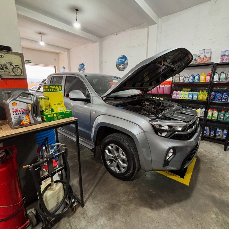 Volkswagen Amarok gris con el capó abierto en el taller