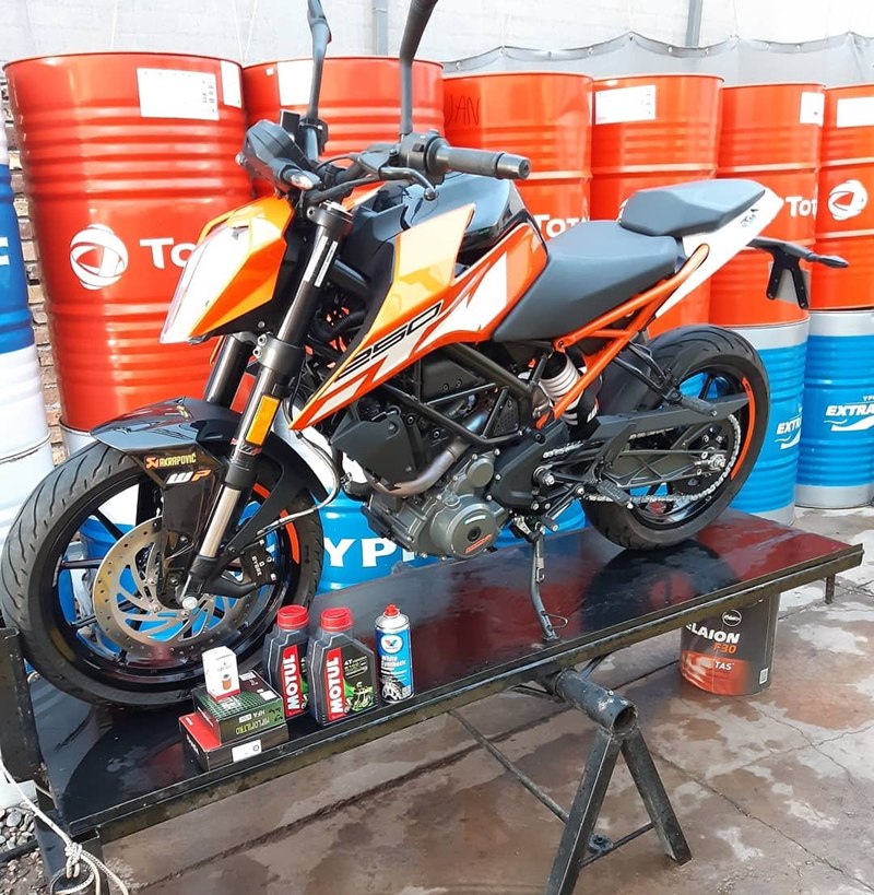 Moto KTM naranja sobre el elevador del lubricentro