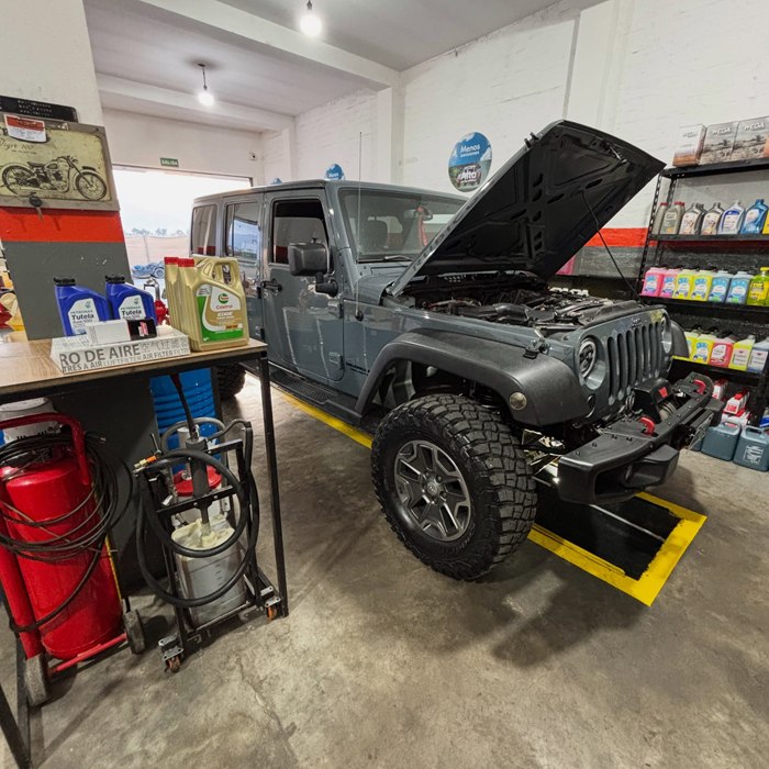 Jeep Wrangler Rubicon gris con el capó abierto en el taller